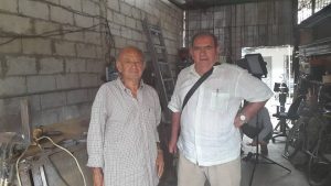 Juanra Etxebarrria, junto a Lucho Hidalgo en su taller antes de comenzar la entrevista. Lucho ha sido un hombre de confianza, mecánico cercano a todos los misioneros y misioneras vascos durante 60 años .